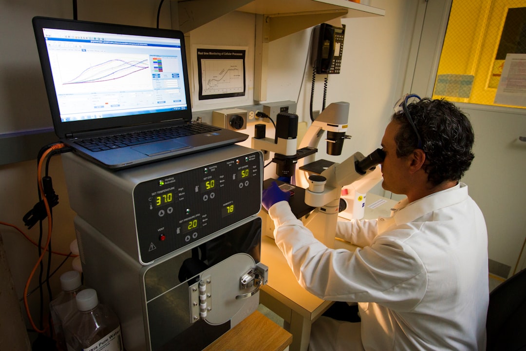 DNA Genotyping and Sequencing. A technician observing cells under a microscope at the Cancer Genomics Research Laboratory, part of the National Cancer Institute